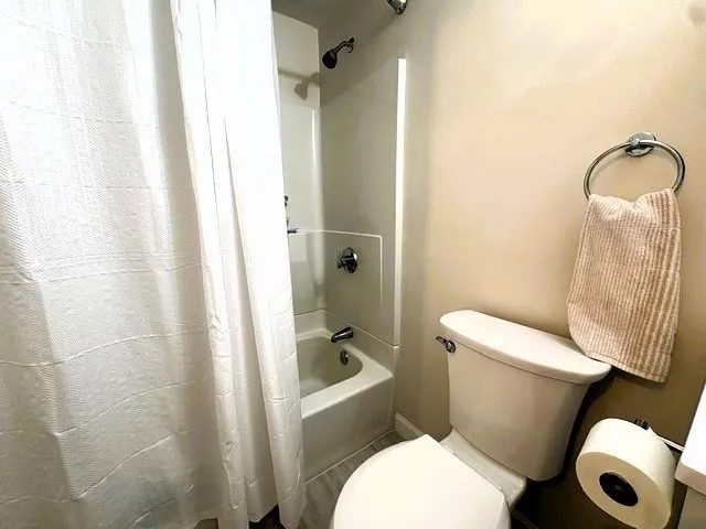 a white toilet sitting next to a bathroom sink and a shower