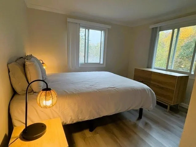 a bedroom with a bed and large windows