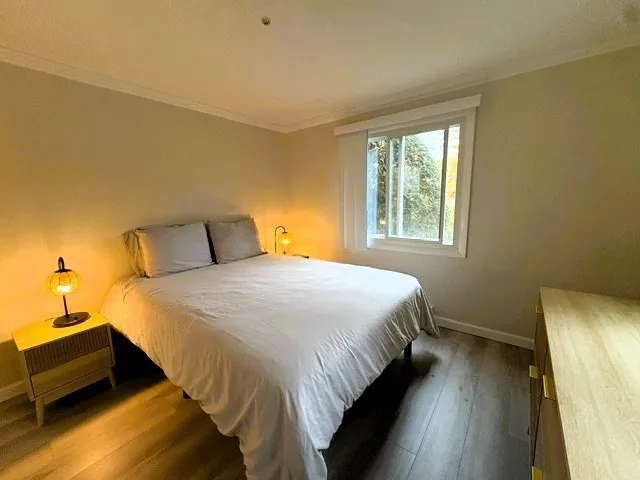 a bedroom with a bed and wooden floor