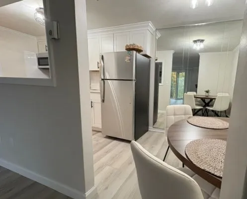 a living room with furniture and a refrigerator