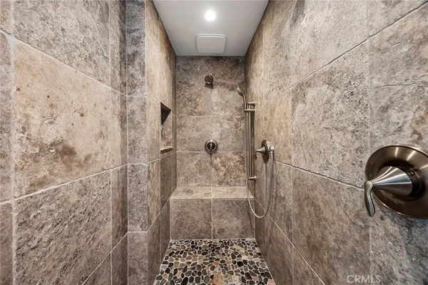 a view of walk in closet with wooden floor and fan