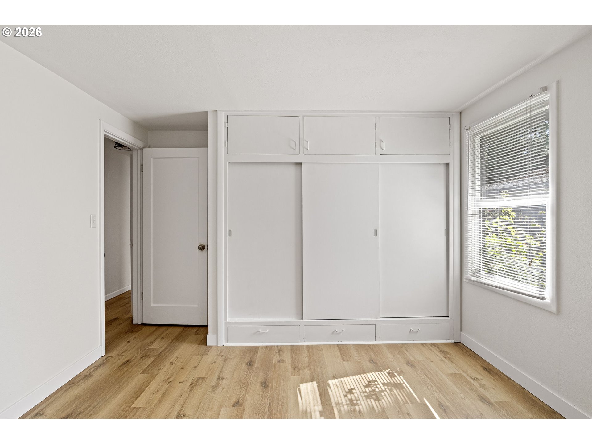 1008 Coburg Road Eugene, OR 97401 - Photo 40 of 46 a view of an empty room with window and wooden floor