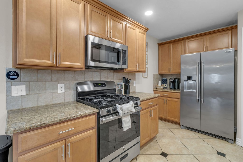 746 Cape Cottage Lane Spring, TX 77373 - Photo 19 of 36 a kitchen with stainless steel appliances granite countertop a refrigerator stove and microwave