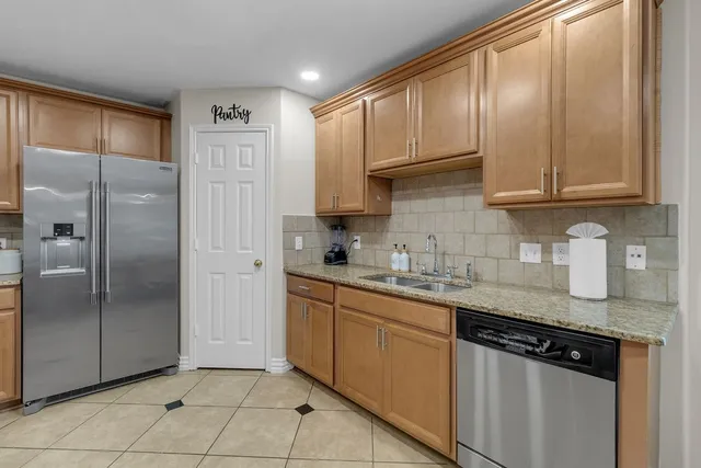 a kitchen with stainless steel appliances granite countertop a refrigerator and sink
