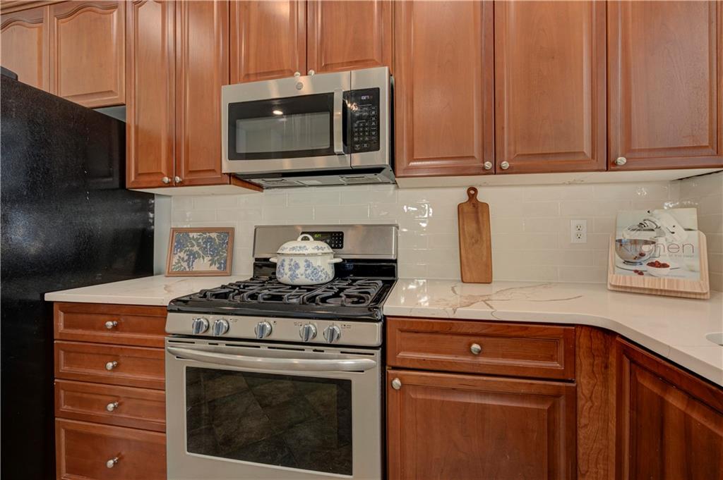 232 Glens Loop Woodstock, GA 30188 - Photo 26 of 52 a kitchen with stainless steel appliances granite countertop a stove microwave and cabinets