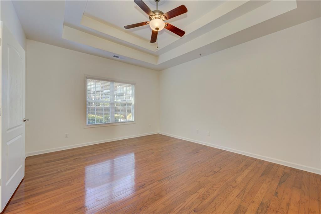 232 Glens Loop Woodstock, GA 30188 - Photo 34 of 52 an empty room with wooden floor chandelier fan and windows