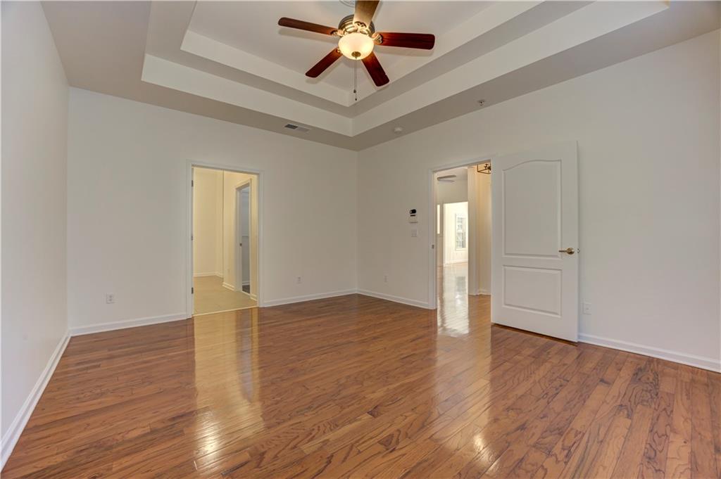 232 Glens Loop Woodstock, GA 30188 - Photo 36 of 52 an empty room with wooden floor chandelier fan and windows