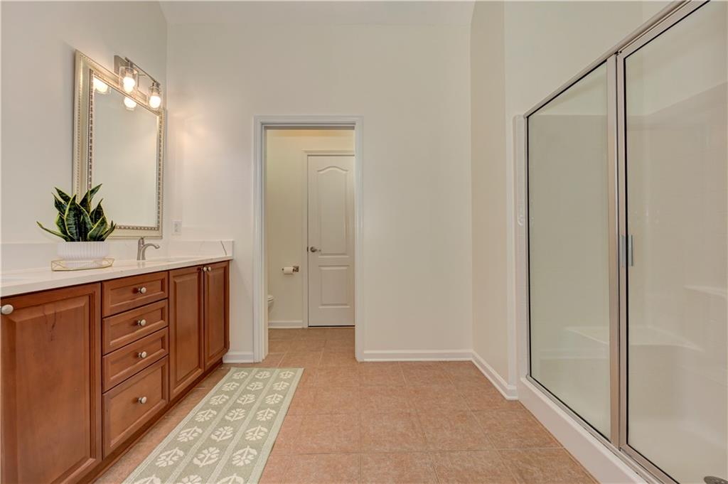 232 Glens Loop Woodstock, GA 30188 - Photo 38 of 52 a spacious bathroom with a granite countertop sink a mirror and a bathtub