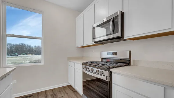 a kitchen with stainless steel appliances white cabinets and a stove