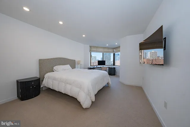 a view of a workspace with furniture and a window