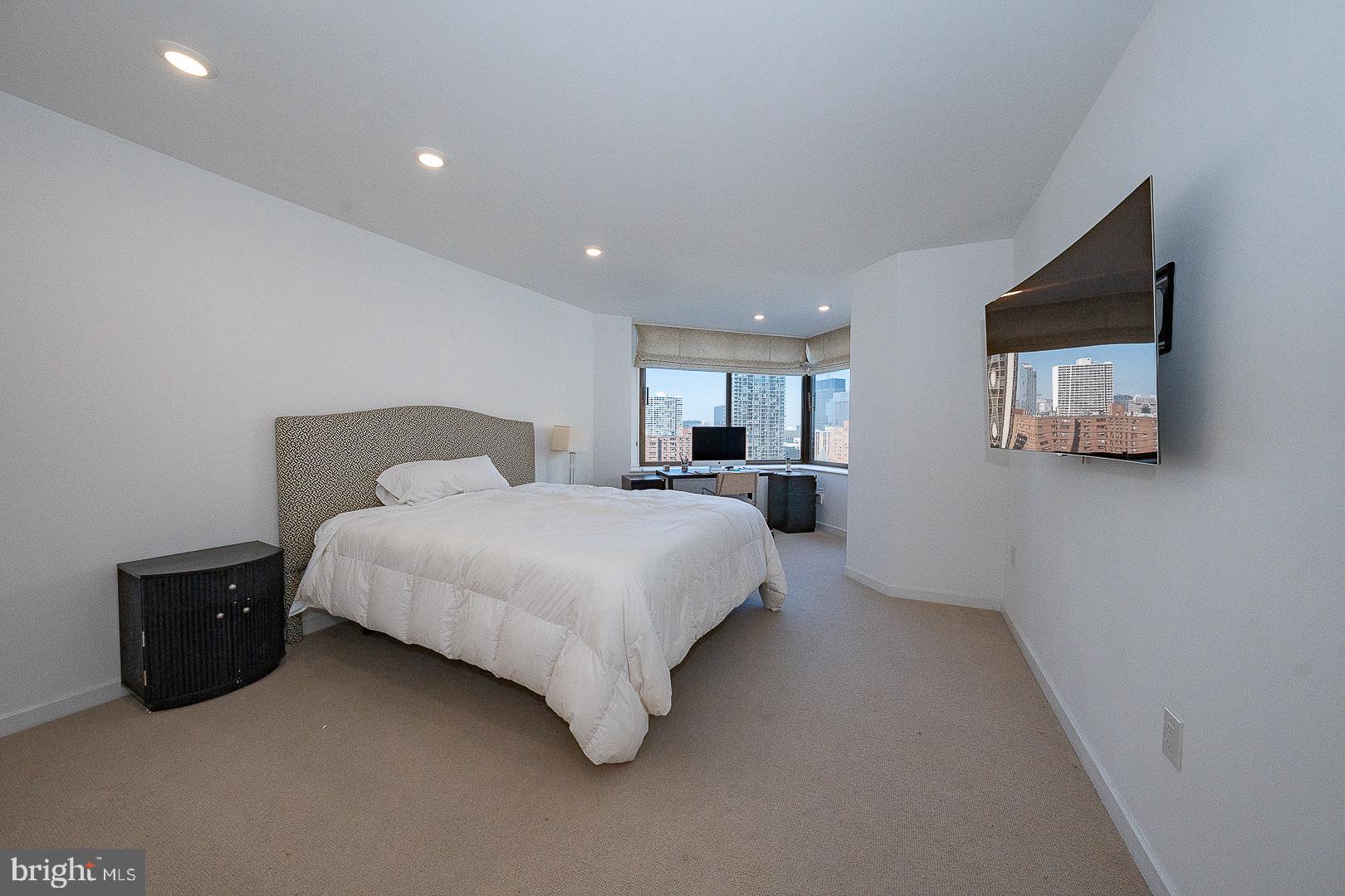 202-10 West Rittenhouse Square, Unit 1205 Philadelphia, PA 19103 - Photo 20 of 28 a spacious bedroom with a bed and a television