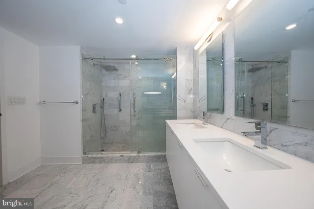 a bathroom with a double vanity sink mirror and shower