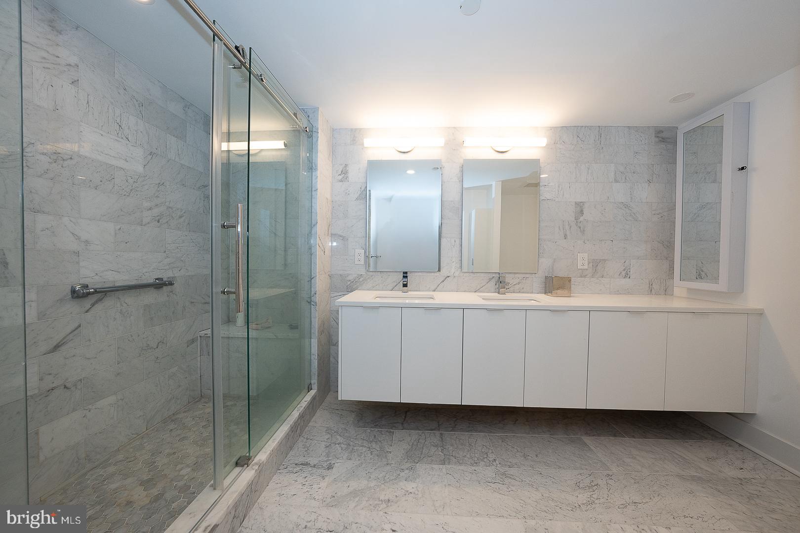 202-10 West Rittenhouse Square, Unit 1205 Philadelphia, PA 19103 - Photo 26 of 28 a bathroom with a double vanity sink mirror and shower