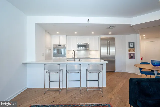 a kitchen with kitchen island a sink stainless steel appliances and cabinets