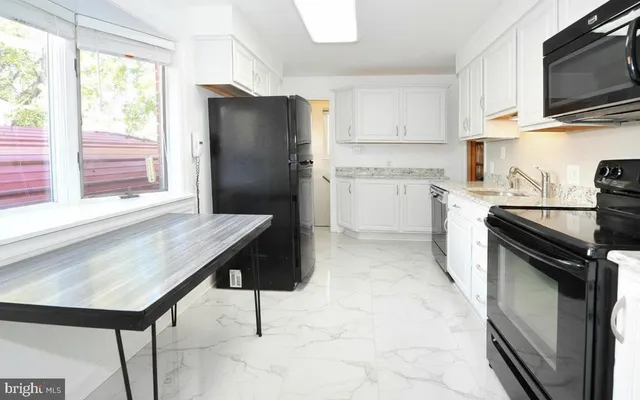 a kitchen with a refrigerator a stove a microwave and cabinets