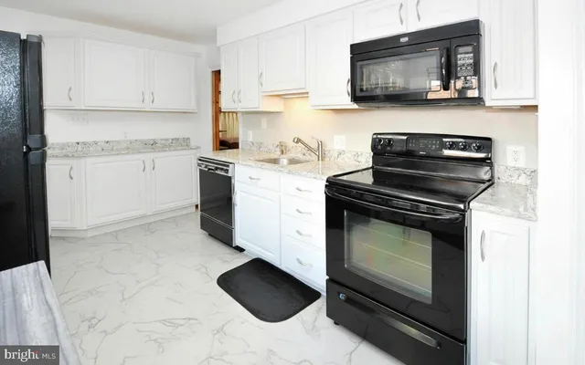 a kitchen with granite countertop a stove and a microwave