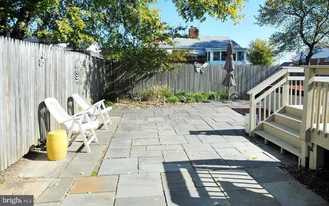a view of a patio with table and chairs with wooden fence and plants