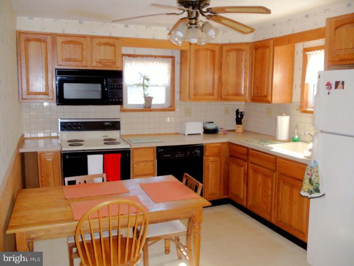 102 Shearers Road Reading, PA 19608 - Photo 4 of 21 a kitchen with stainless steel appliances a sink dishwasher a stove a microwave oven with cabinets and wooden floor