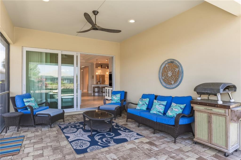 6939 Cay Court Naples, FL 34113 - Photo 21 of 31 Rear view of house featuring a sunroom, stucco siding, a lanai, and a lawn