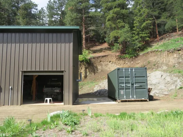 a view of a house with a small yard and a large tree