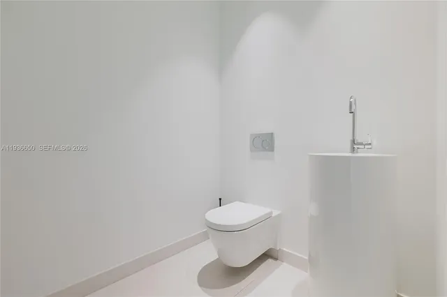 a white toilet sitting next to a white cabinet