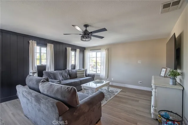 a view of a livingroom with a window wooden floor and a ceiling fan