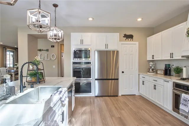 a kitchen with kitchen island granite countertop stainless steel appliances and a chandelier