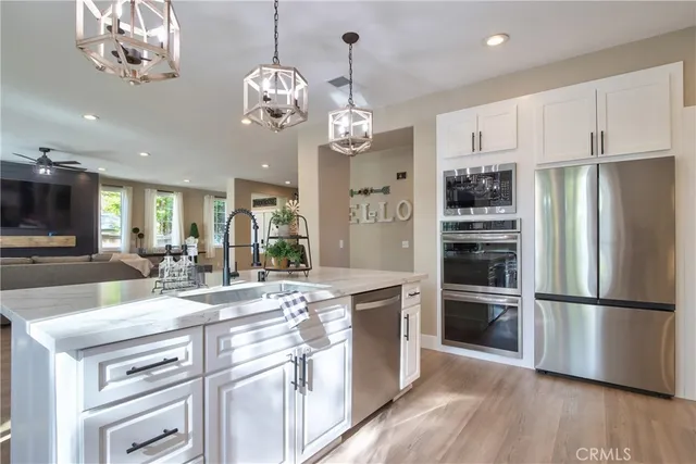 a kitchen with stainless steel appliances kitchen island granite countertop a table chairs and cabinets