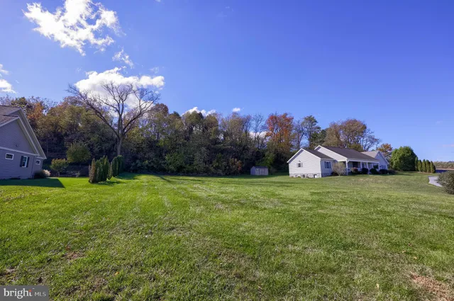 a view of a house with a big yard and large trees