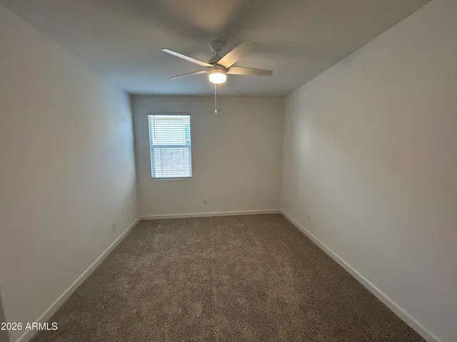an empty room with a window and a fan