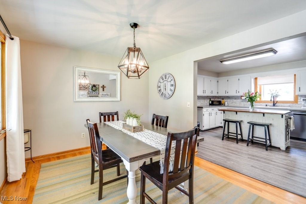 5867 Wiclif Road Northeast Canton, OH 44721 - Photo 10 of 45 Dining room featuring a chandelier, light wood-style floors, and baseboards
