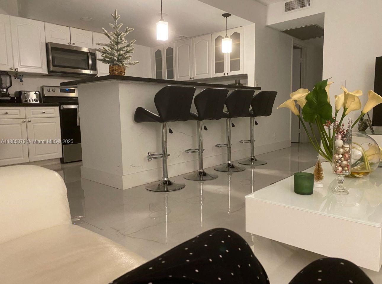 13255 Southwest 9th Court, Unit 307G Pembroke Pines, FL 33027 - Photo 2 of 10 a kitchen with stainless steel appliances granite countertop a sink a stove and cabinets