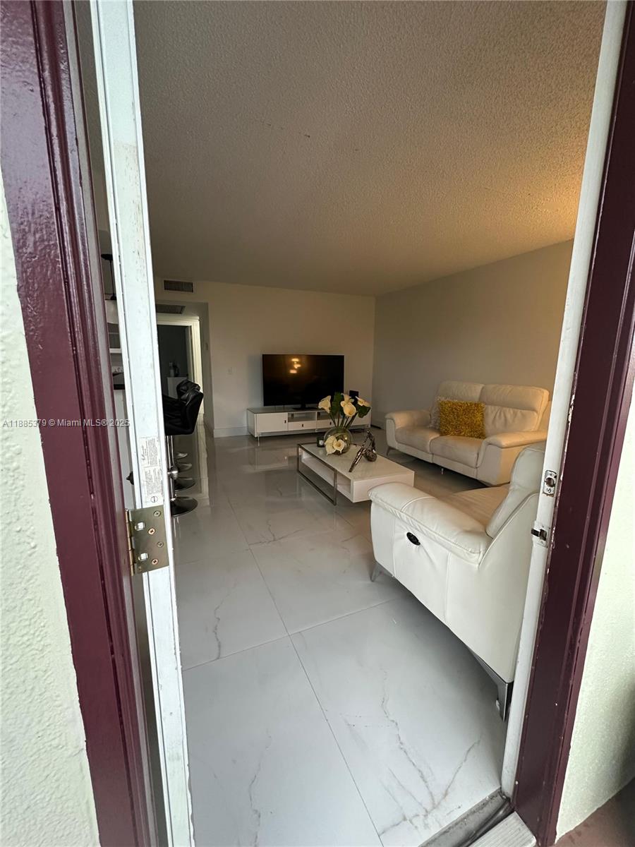 13255 Southwest 9th Court, Unit 307G Pembroke Pines, FL 33027 - Photo 3 of 10 a living room with furniture and a window
