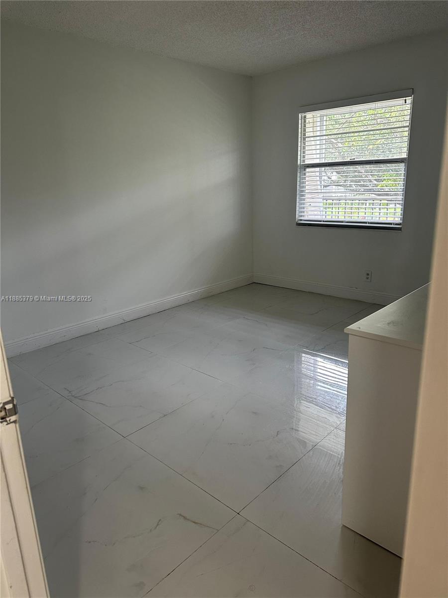 13255 Southwest 9th Court, Unit 307G Pembroke Pines, FL 33027 - Photo 5 of 10 an empty room with windows