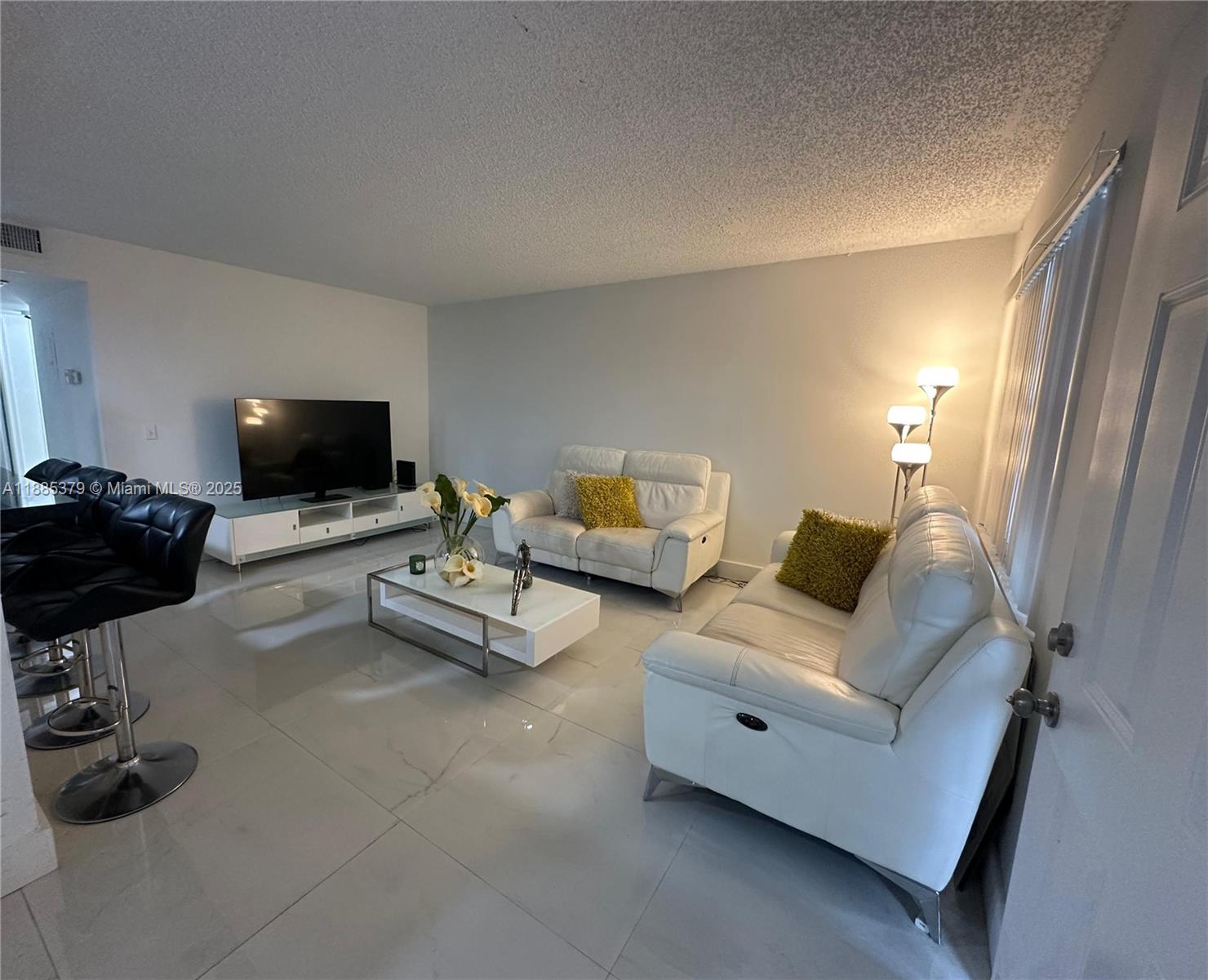 13255 Southwest 9th Court, Unit 307G Pembroke Pines, FL 33027 - Photo 6 of 10 a living room with furniture and a flat screen tv