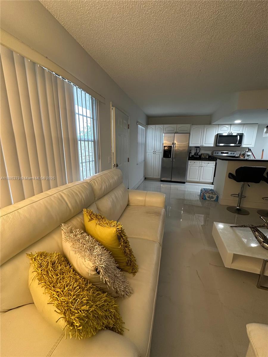 13255 Southwest 9th Court, Unit 307G Pembroke Pines, FL 33027 - Photo 7 of 10 a living room with furniture and a large window