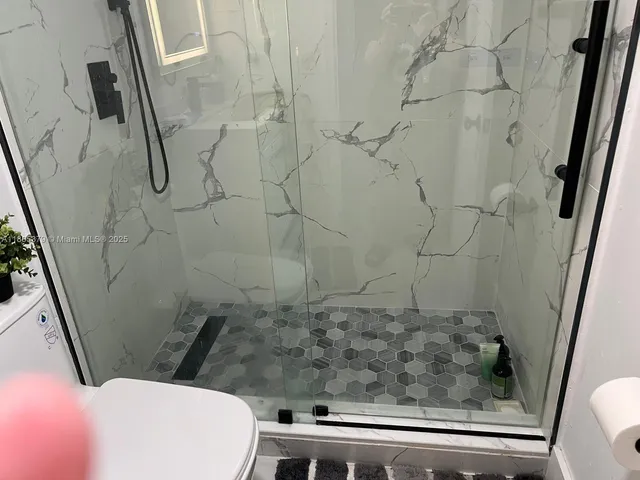a bathroom with a toilet and a shower