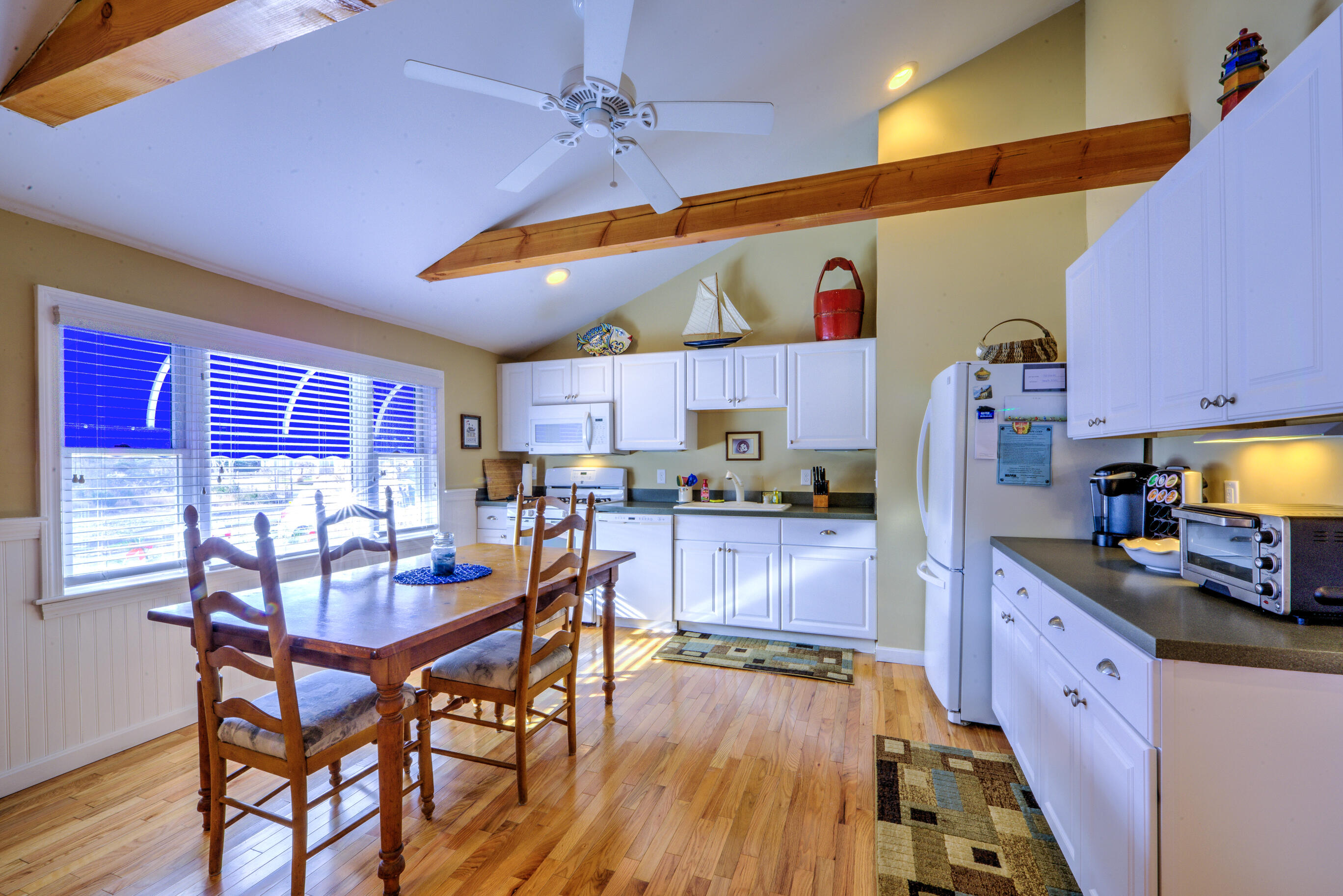 131 North Shore Boulevard, Unit 2A East Sandwich, MA 02537 - Photo 4 of 13 a kitchen with stainless steel appliances kitchen island granite countertop a table chairs in it and wooden floors