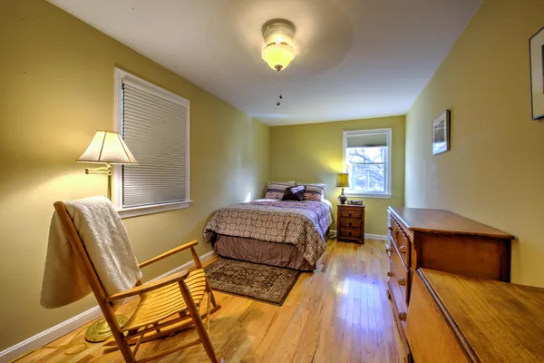 a bedroom with a bed and a lamp with wooden floor