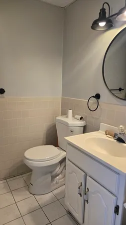 a bathroom with a sink mirror vanity and toilet