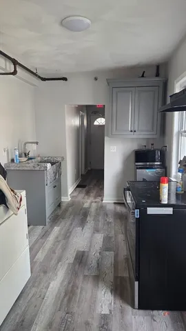 a kitchen with granite countertop a refrigerator stove and sink