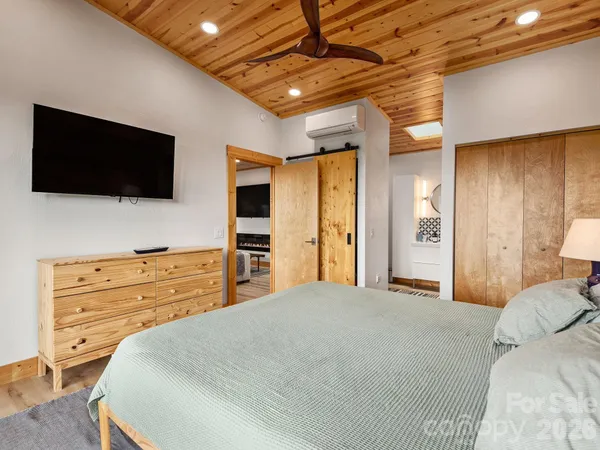 a bedroom with a large bed and flat screen tv