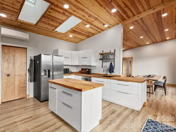 a kitchen with stainless steel appliances granite countertop a table chairs refrigerator and sink