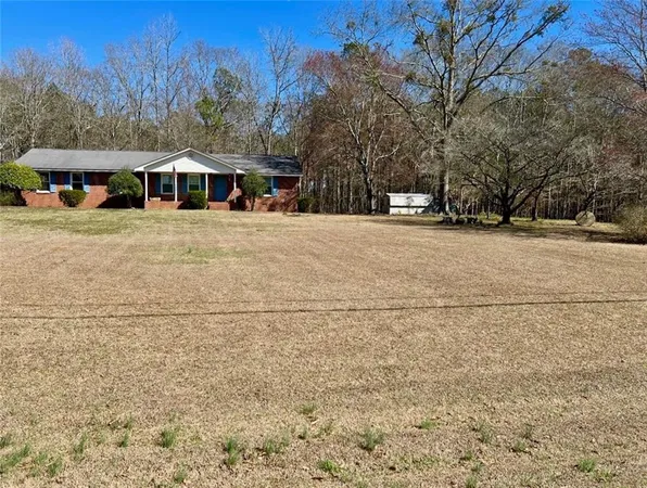 a front view of a house with a yard and trees