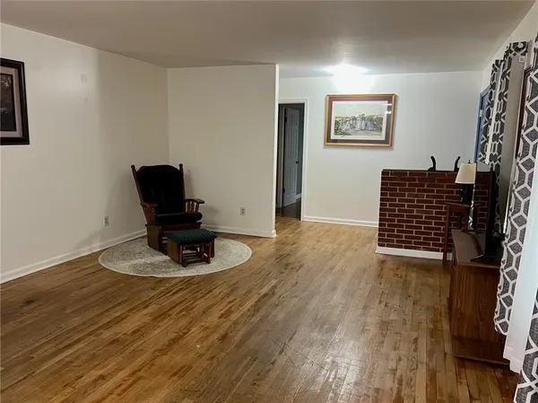 a view of an empty room with furniture and wooden floor