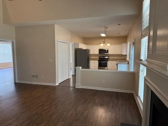 a view of a kitchen with wooden floor and electronic appliances