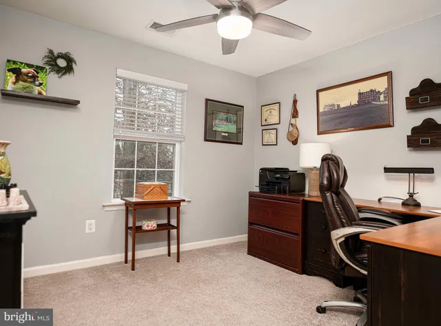 a view of a workspace with furniture and a window