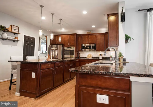 a kitchen with kitchen island granite countertop wooden cabinets and a refrigerator