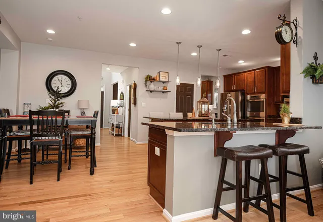 a kitchen with stainless steel appliances granite countertop table chairs and chandelier