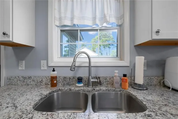 a kitchen with a sink cabinets and a window
